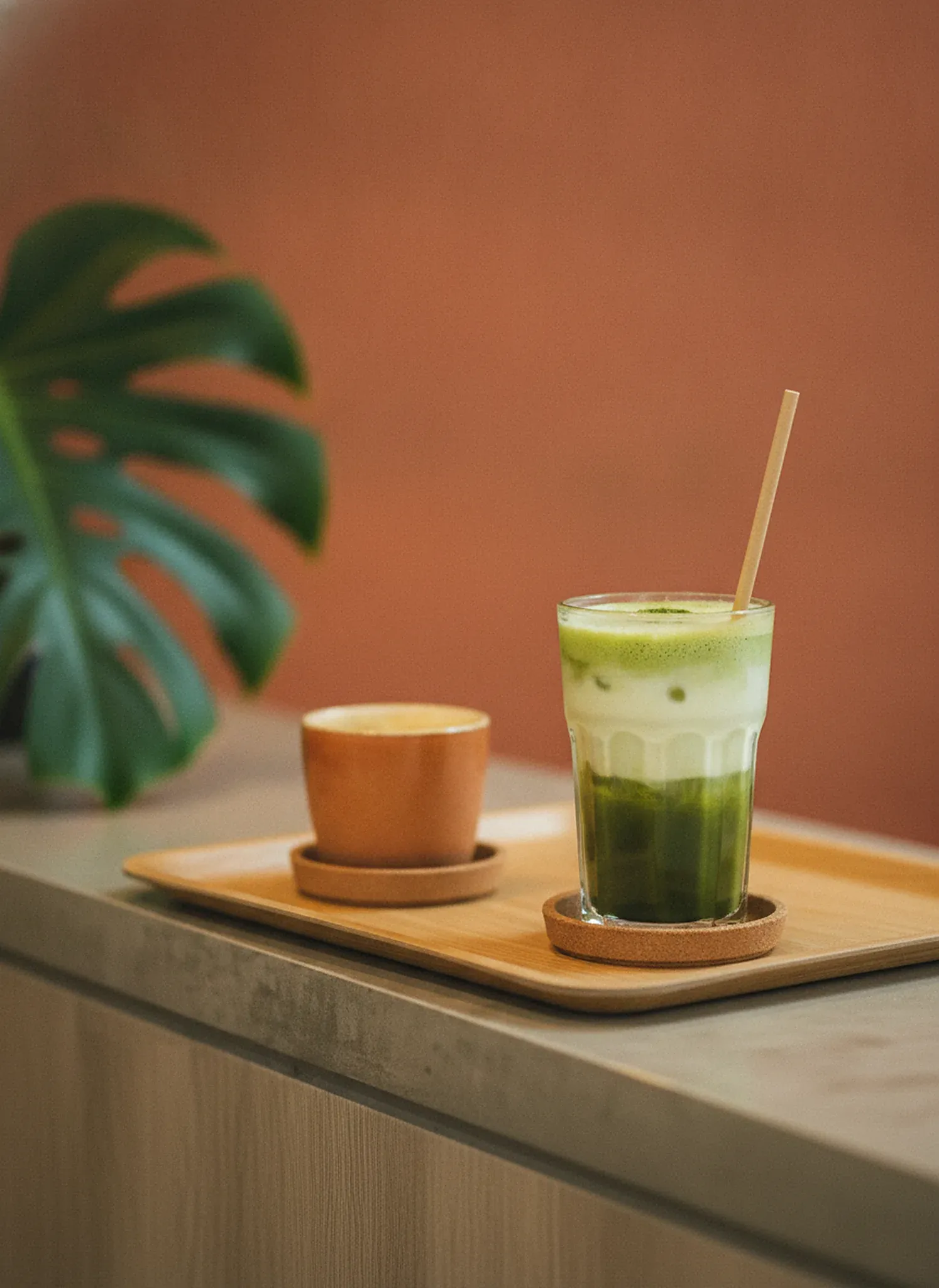 Grüner Matcha im Glas auf einem Holztablett
